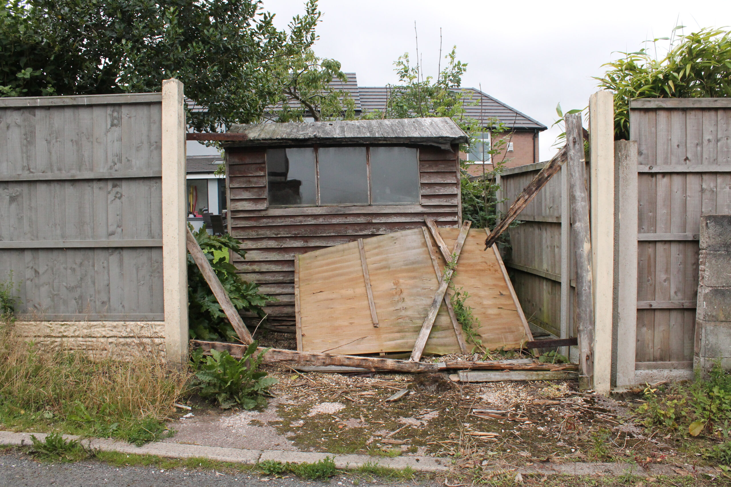 broken garden shed and fence