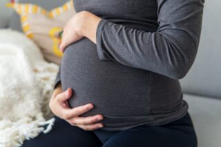 Pregnant woman holding her belly.